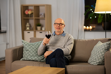 Image showing senior man drinking red wine from glass at home