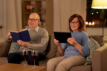 Image showing senior couple with book and tablet pc at home