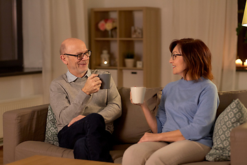 Image showing happy senior couple drinking tea at home at night