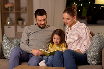 Image showing happy family reading book at home at night