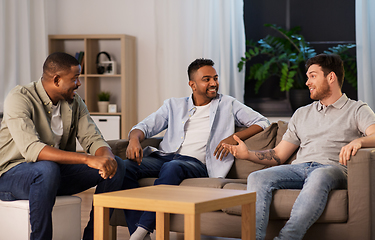 Image showing happy male friends talking at home at night