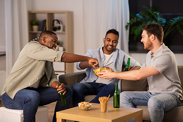 Image showing male friends drinking beer with crisps at home