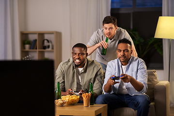 Image showing happy friends playing video games at home at night