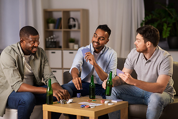 Image showing happy male friends playing cards at home at night