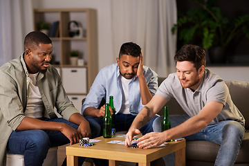 Image showing male friends playing cards at home at night