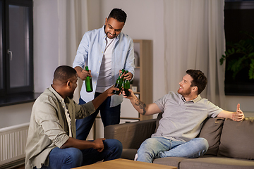 Image showing happy male friends drinking beer at home at night