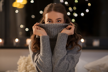 Image showing young woman in woolen sweater at home at night