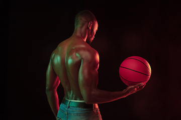 Image showing Young african-american basketball player against dark background