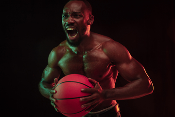 Image showing Young african-american basketball player against dark background