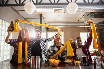 Image showing Group of friends watching sport match together. Emotional fans cheering for favourite team, watching on exciting game. Concept of friendship, leisure activity, emotions