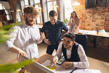 Image showing Colleagues working together in modern office using devices and gadgets during creative meeting