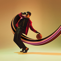 Image showing Beautiful basketball player with long fluid flood on gradient background. Negative space to insert your text. Modern design. Contemporary colorful and conceptual bright art collage.