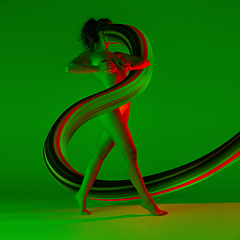 Image showing Fit sportive woman with long fluid flood on gradient background. Negative space to insert your text. Modern design. Contemporary colorful and conceptual bright art collage.