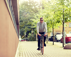 Image showing young man riding bicycle on city street