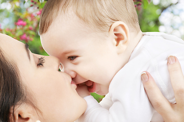 Image showing close up of mother kissing baby over garden