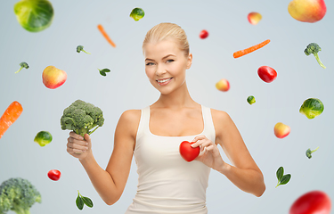 Image showing happy smiling young woman with heart and broccoli