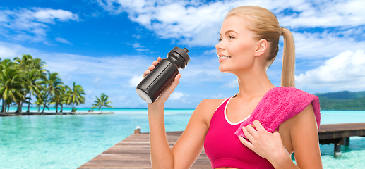 Image showing happy smiling woman with sports bottle and towel