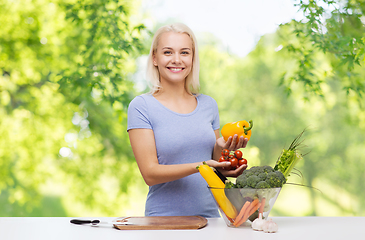 Image showing smiling young woman cooking vegetables