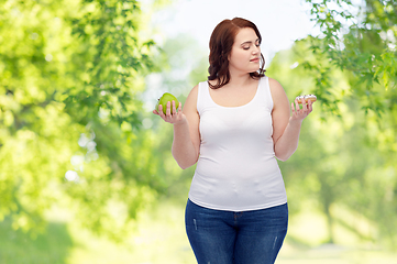 Image showing plus size woman choosing between apple and donut