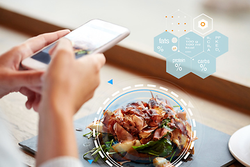 Image showing hands with phone and food nutritional value chart