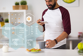 Image showing man with phone and food nutritional value chart