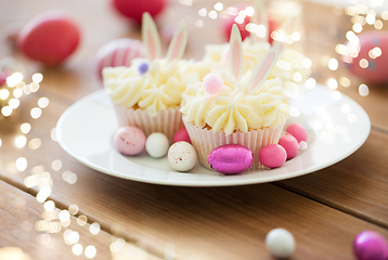 Image showing cupcakes with easter eggs and candies on table