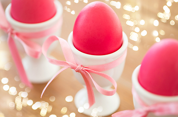 Image showing pink colored easter eggs in holders on table