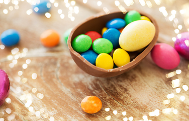 Image showing chocolate easter egg and candy drops on table