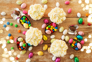 Image showing cupcakes with chocolate eggs and candies on table