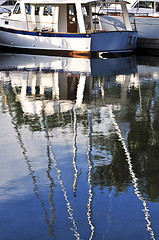 Image showing Moored sailboats reflecting in water