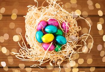 Image showing chocolate easter eggs in straw nest on table