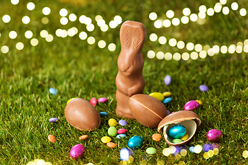 Image showing chocolate bunny, eggs and candy drops on grass