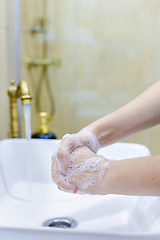 Image showing Woman washing and disinfecting hands with soap and hot water