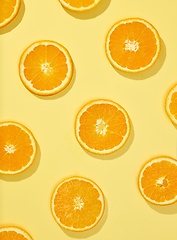 Image showing fresh orange slices on yellow background