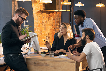 Image showing Colleagues working together in modern office using devices and gadgets during creative meeting