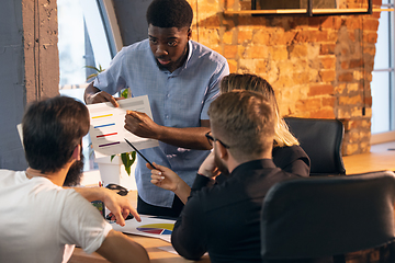 Image showing Colleagues working together in modern office using devices and gadgets during creative meeting