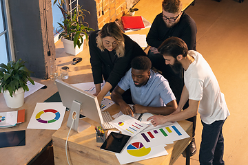 Image showing Colleagues working together in modern office using devices and gadgets during creative meeting