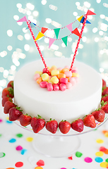 Image showing close up of birthday cake with garland on stand