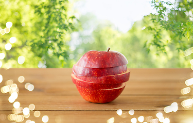 Image showing sliced red apple on wooden table