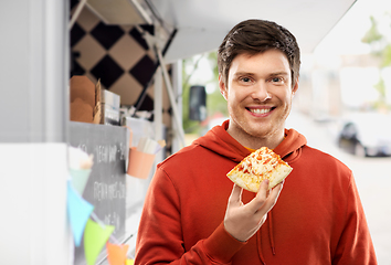 Image showing happy young man eating pizza at food truck