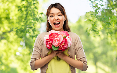 Image showing happy laughing asian woman with bunch of flowers