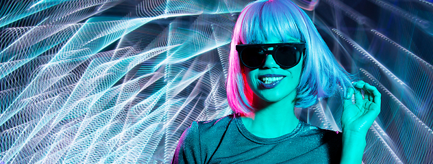 Image showing happy woman in wig and sunglasses over neon lights