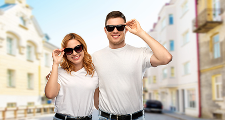 Image showing happy couple in t-shirts and sunglasses in city