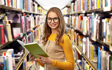 Image showing student girl in glasses reading book at library