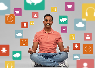 Image showing happy man in yoga lotus pose over app icons