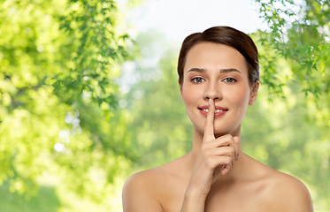 Image showing beautiful young woman holding finger on lips