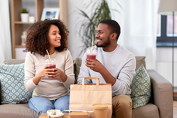 Image showing happy couple with takeaway food and drinks at home