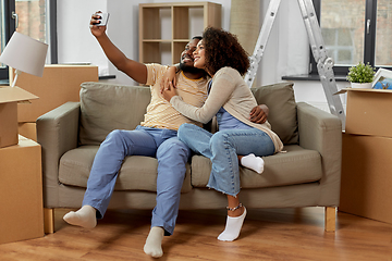 Image showing happy couple moving to new home and taking selfie