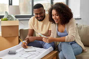 Image showing couple with blueprint counting money at home