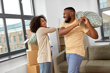 Image showing happy couple having pillow fight at new home